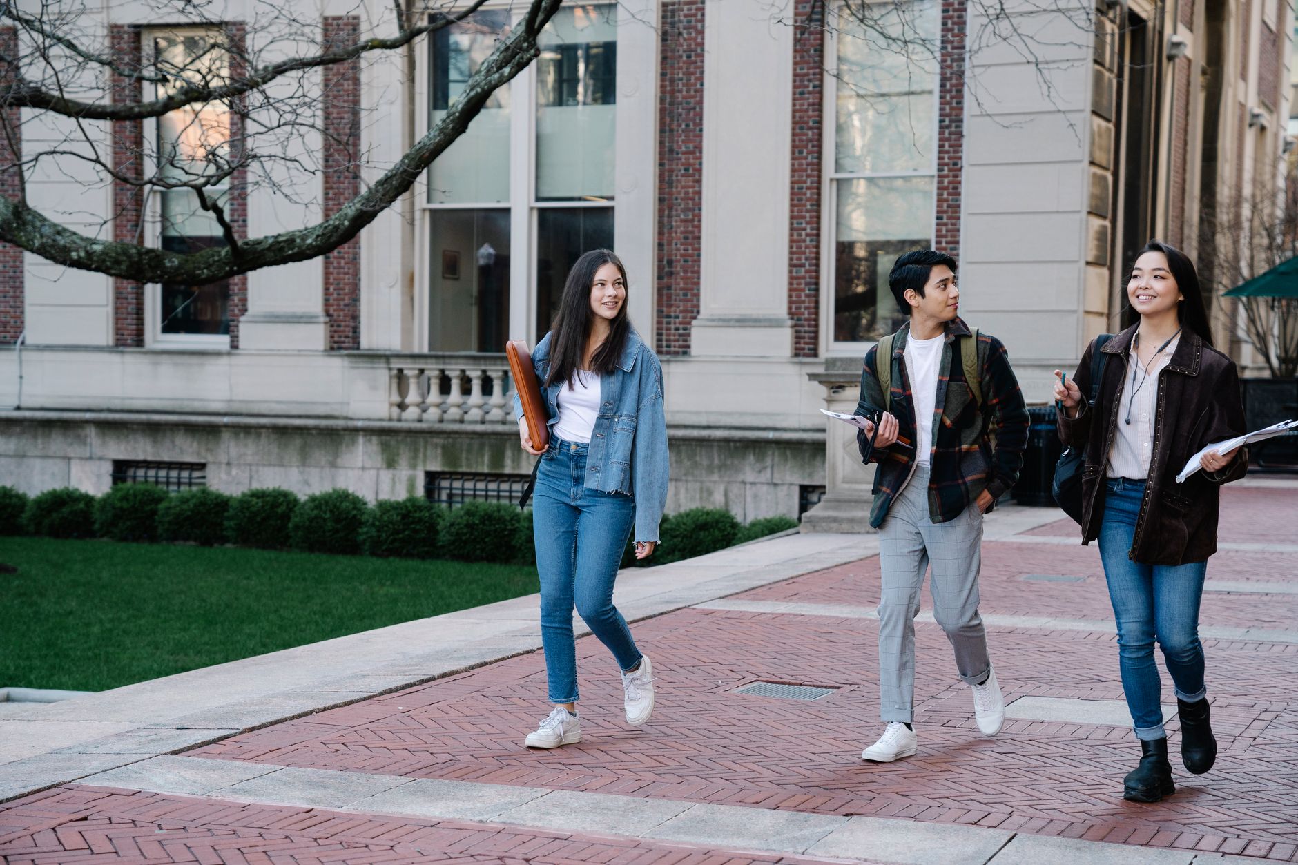 group of people walking on a sidewalk